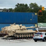 train-collides-with-military-mobile-artillery-vehicle-being-hauled-on-a-semi-truck