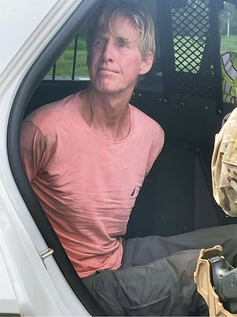 suspect-in-trump’s-would-be-assassin-ryan-routh-appears-calm-as-he-sits-handcuffed-in-back-of-police-car:-arrest-photo