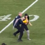 woman-runs-onto-field-waving-pro-trump-sign-during-jets-steelers-game