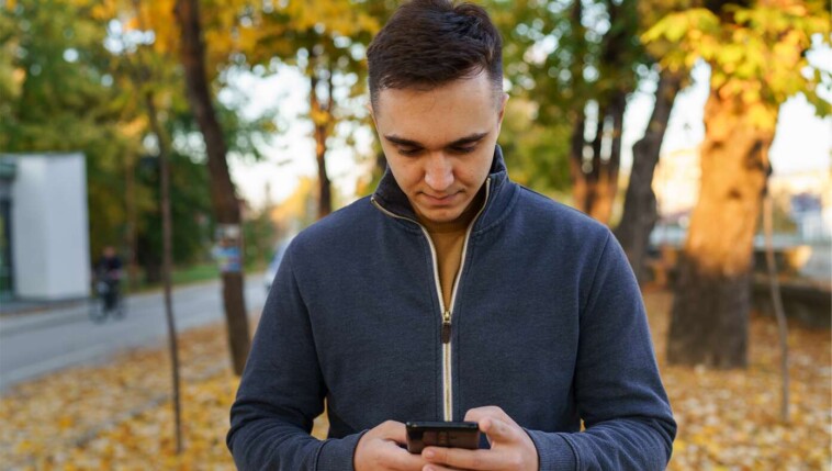 sad:-man-almost-lets-beautiful-autumn-day-distract-him-from-doomscrolling-on-phone