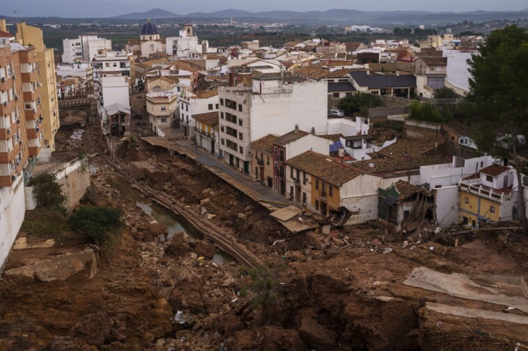 mud-caked-volunteers-clean-flood-debris-in-a-spanish-town-as-authorities-struggle-to-respond