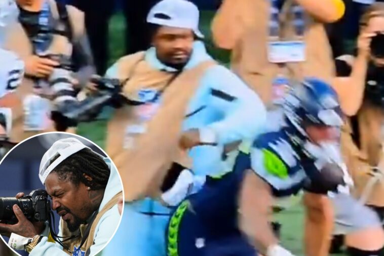 marshawn-lynch-stiff-arms-player-to-protect-his-camera-during-seahawks-preseason-game-in-wild-scene