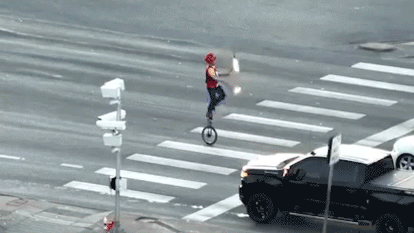 fire-juggling-unicyclist-caught-on-camera-blocking-traffic-in-major-roadway-as-police-intervene