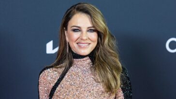 elizabeth-hurley-strips-down-to-bikini-bottoms-for-racy-photo-while-posing-in-a-flower-field