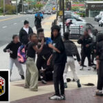 swarm-of-middle-schoolers-laugh,-smile-at-camera-as-brawling-peers-stomp-on-victim-in-wild-street-fight