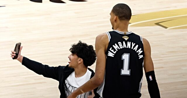 look-at-me!-rogue-selfie-hunting-fan-stops-game-1-of-nba-finals-for-shot-with-victor-wembanyama