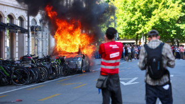 anti-g7-protest-turns-violent-as-demonstrators-torch-tesla-and-smash-un-office-windows
