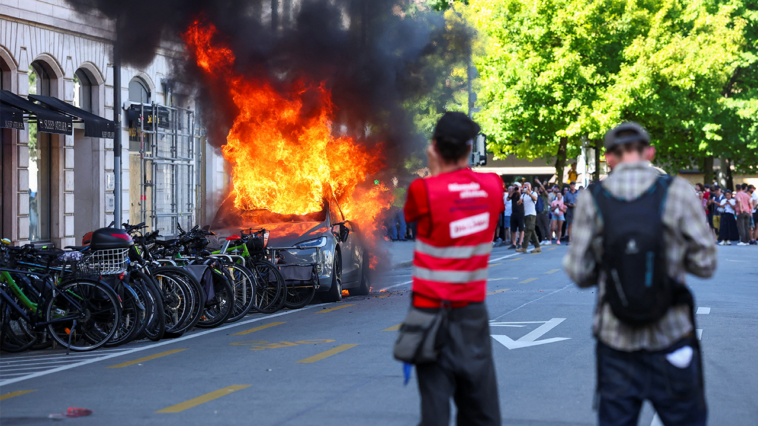 anti-g7-protest-turns-violent-as-demonstrators-torch-tesla-and-smash-un-office-windows