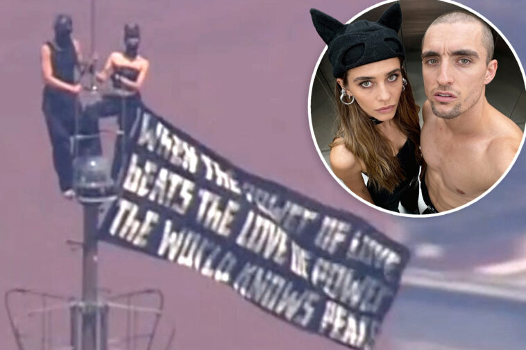 kissing-daredevils-scale-empire-state-building-antenna,-hanging-flag-1,454-feet-over-nyc-with-cringe-message
