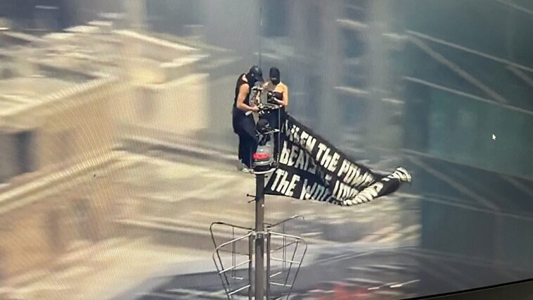 two-people-climb-to-the-top-of-empire-state-building-with-massive-banner