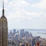 two-people-climb-to-the-top-of-empire-state-building-antenna,-fly-banner-with-message