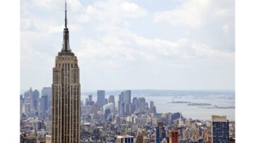 two-people-climb-to-the-top-of-empire-state-building-antenna,-fly-banner-with-message