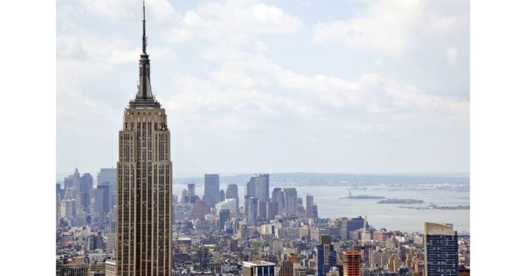 two-people-climb-to-the-top-of-empire-state-building-antenna,-fly-banner-with-message