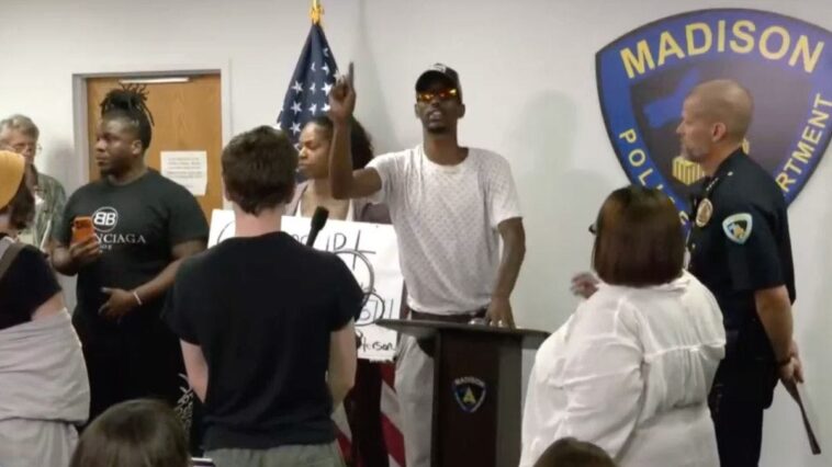watch-how-police-react-as-screaming-protester-takes-over-briefing-on-fatal-shooting
