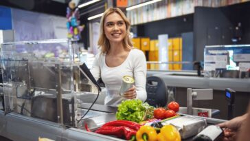 teenage-cashier-desperately-hoping-middle-aged-man-will-start-up-small-talk-with-her
