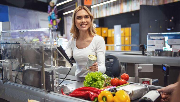 teenage-cashier-desperately-hoping-middle-aged-man-will-start-up-small-talk-with-her