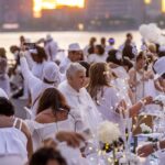 dinner-party-has-guests-bringing-tables,-dressing-in-white-and-learning-location-last-minute