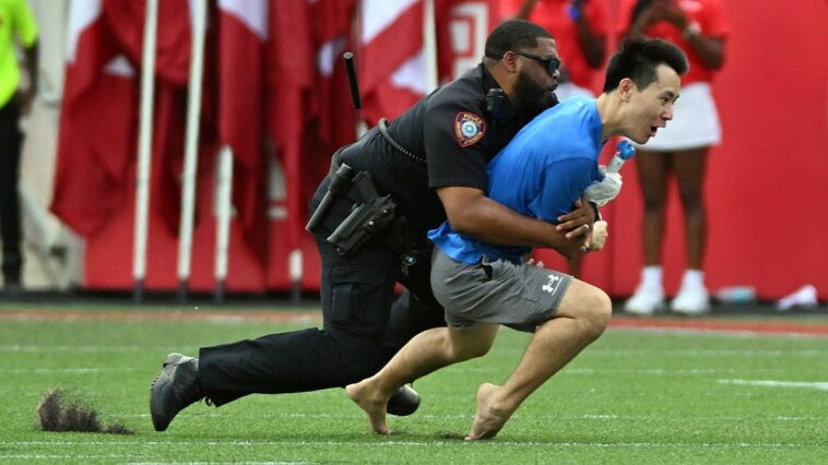 fan-runs-onto-field-at-houston-cougars-game,-gets-absolutely-trucked-by-police-officer