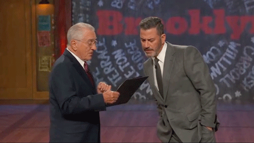 robert-de-niro-jokingly-prods-jimmy-kimmel-with-a-baseball-bat-while-posing-as-fcc-chair,-threatens-host