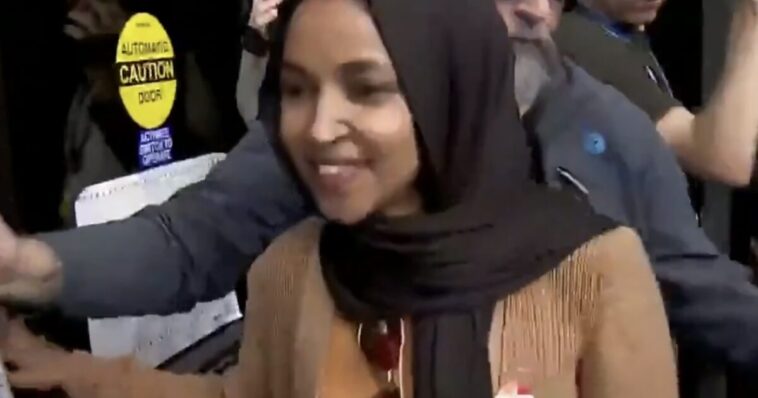 ilhan-omar’s-handlers-rush-her-away-from-the-press-as-she-remains-defiant-amid-questions-about-federal-investigations-(video)